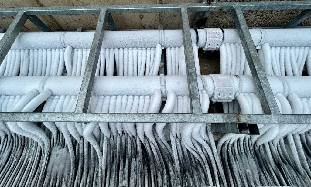 a metal frame with pipes covered in ice