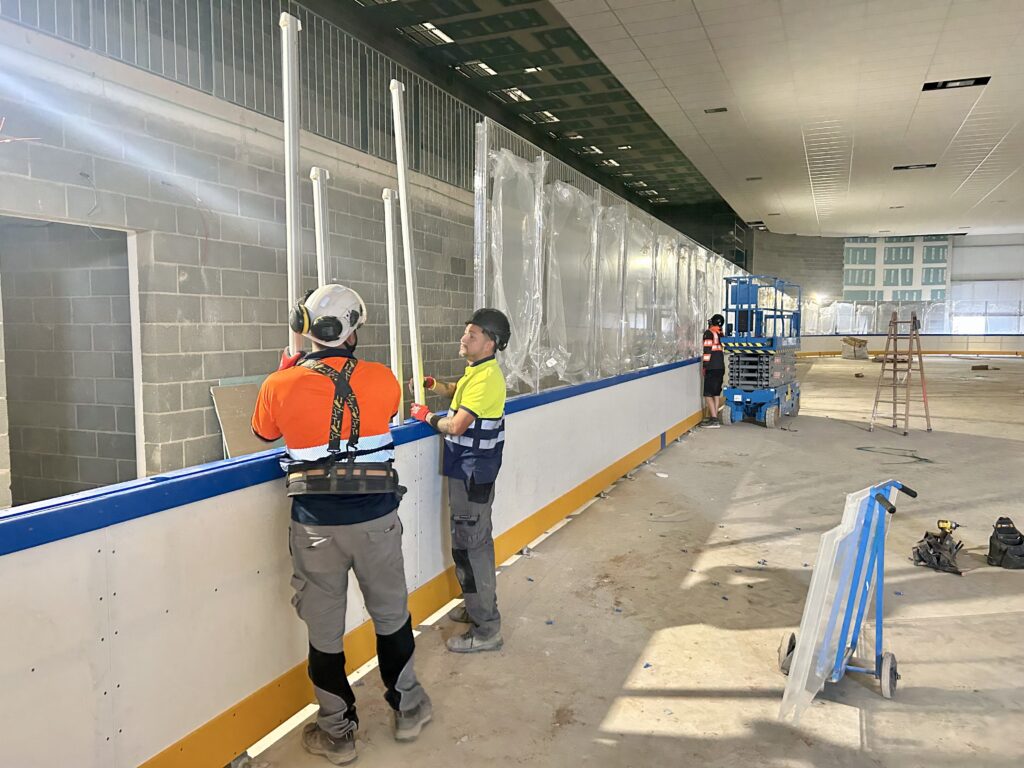 Instalacion de nuevas barreras profesionales alrededor de una pista de hielo renovada